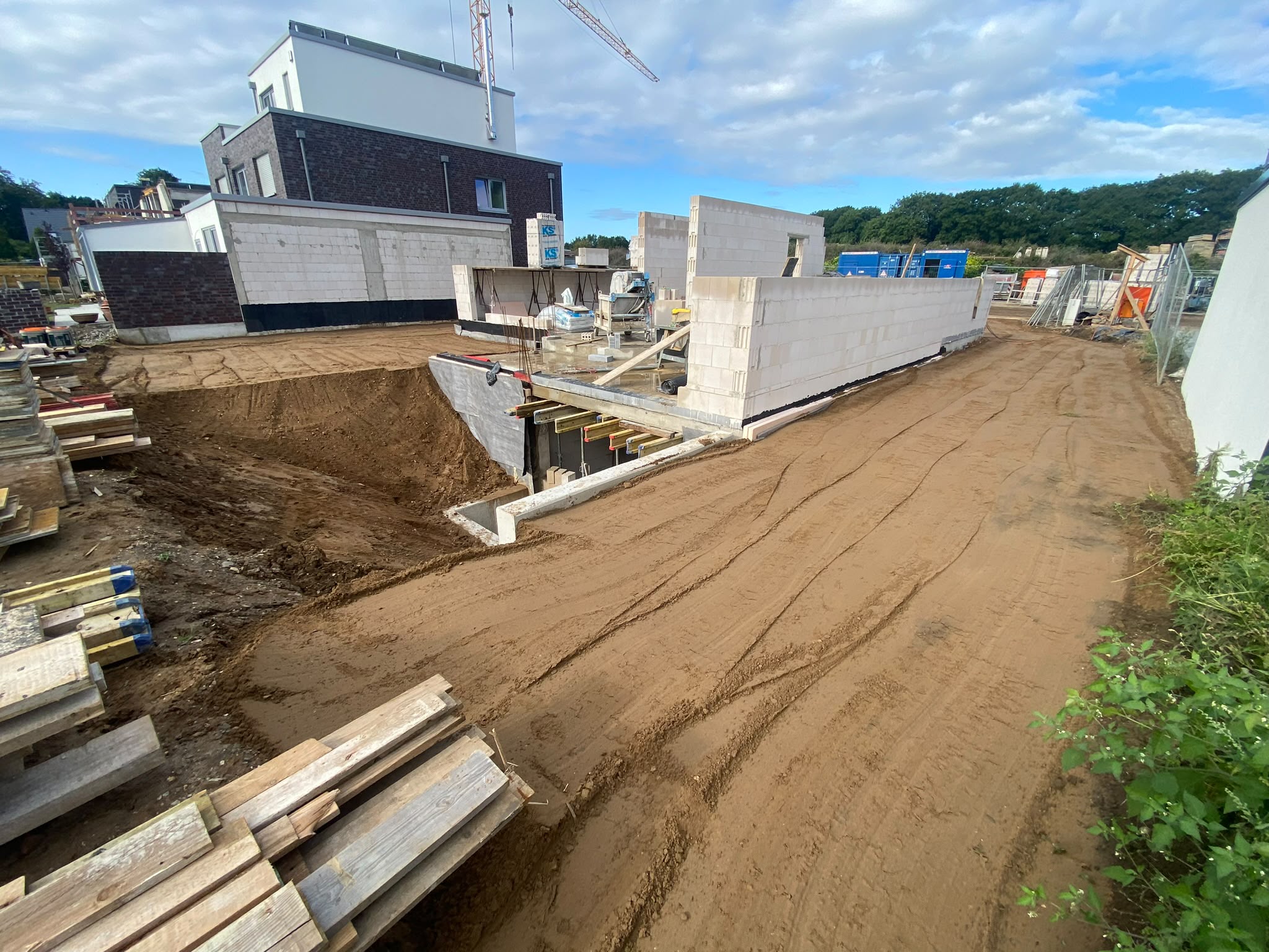 Baustelle mit Rohbau und aufgeschüttetem Erdreich, begleitet von Dieter Drüen